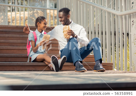 Positive delighted international family having lunch outdoors 56358991