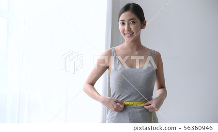 Healthy concept. Asian girls are measuring her 56360946