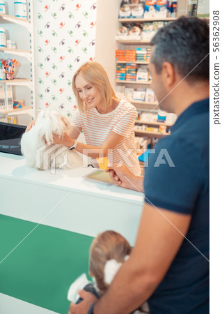 Man paying for dog by card while buying it for daughter 56362908