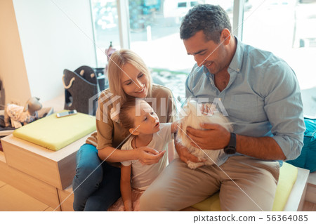Daughter feeling satisfied while touching white fluffy dog 56364085