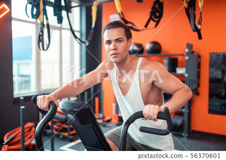 Handsome serious man sitting on the sports machine 56370601