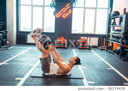 Pleasant handsome man lying on the training mat 56374439