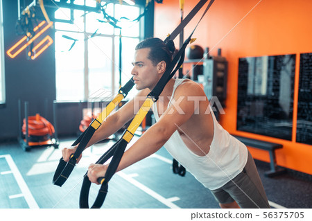 Good looking well built man having a trx training 56375705