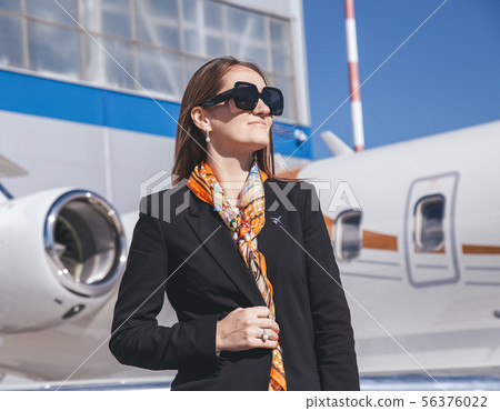 beautiful young business woman near the airplane jet at sunny day in airport beautiful young business woman near the airplane jet at sunny day in airport 56376022