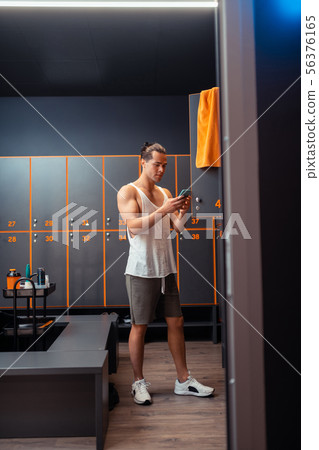 Attractive fit man typing a message on the smartphone 56376165