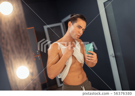 Attractive fit man taking a photo in the mirror 56376380