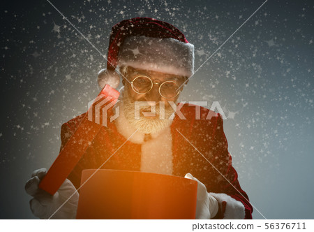 Elderly Santa Claus holding box with light inside Elderly Santa Claus holding box with light inside 56376711