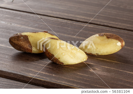 Unshelled brazil nut on brown wood 56381104