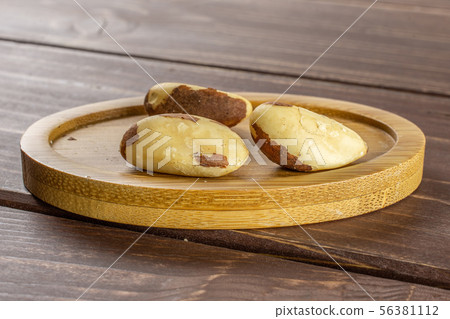 Unshelled brazil nut on brown wood Unshelled brazil nut on brown wood 56381112