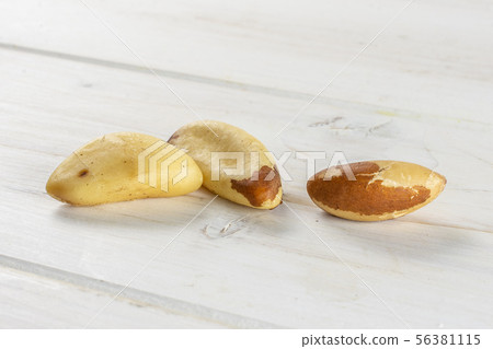 Unshelled brazil nut on grey wood Unshelled brazil nut on grey wood 56381115