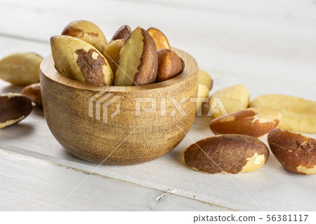 Unshelled brazil nut on grey wood Unshelled brazil nut on grey wood 56381117