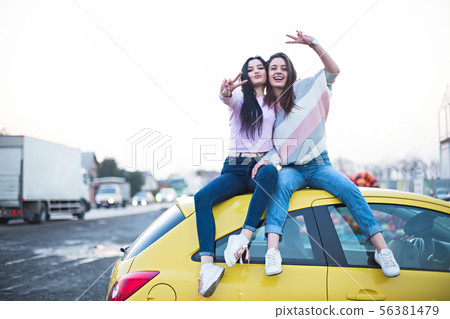 Best female friends cheering by car road trip at Best female friends cheering by car road trip at 56381479