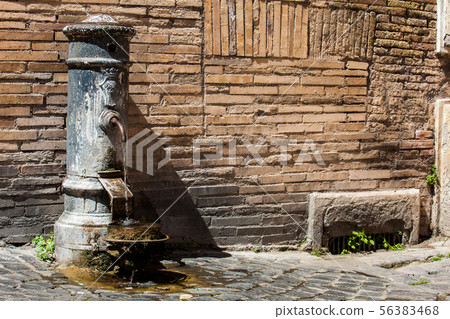 Typical antique public drinking fountain in Rome 56383468