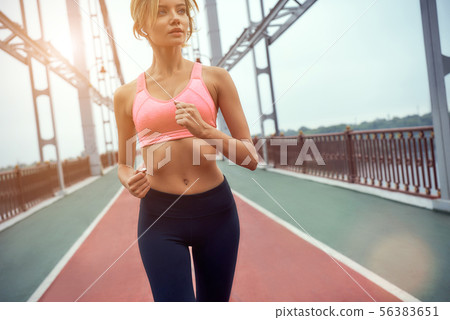 Never give up Young and beautiful blonde woman in sports clothing jogging on the bridge Never give up Young and beautiful blonde woman in sports clothing jogging on the bridge 56383651