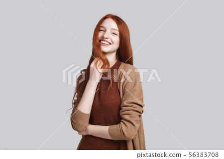Sunny girl. Portrait of positive and cute young redhead lady in casual clothing smiling at camera Sunny girl. Portrait of positive and cute young redhead lady in casual clothing smiling at camera 56383708