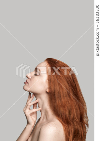 Perfect chin. Side view of young and beautiful redhead woman touching her soft skin and keeping eyes Perfect chin. Side view of young and beautiful redhead woman touching her soft skin and keeping eyes 56383830