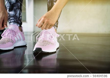 Close up women hand tying running shoe in gym 56404596