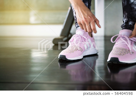 Close up women hand tying running shoe in gym 56404598