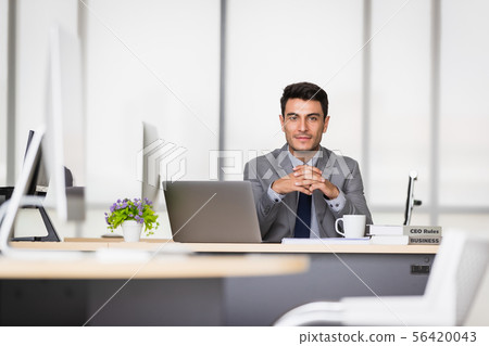 Caucasian businessman holding a pen in his hands.. Caucasian businessman holding a pen in his hands.. 56420043