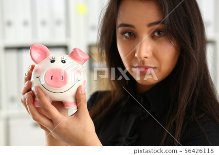 woman hold piggybank in arms 56426118