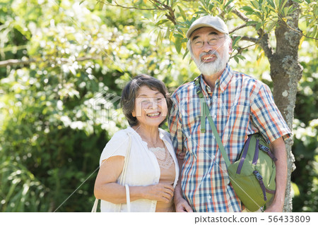 資深日本夫婦公園步行樹綠色微笑 56433809