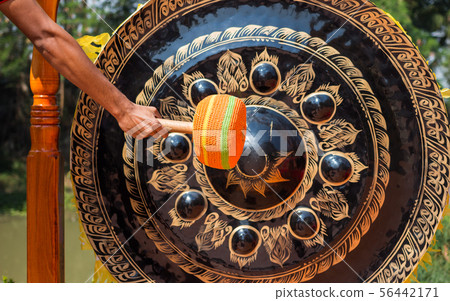 Hand hit big gong in temple 56442171