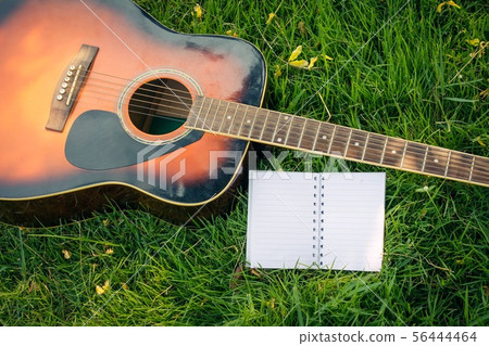 Paper for writing songs with a guitar on the lawn Paper for writing songs with a guitar on the lawn 56444464