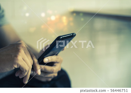 Closeup of hands using mobile in city. 56446751