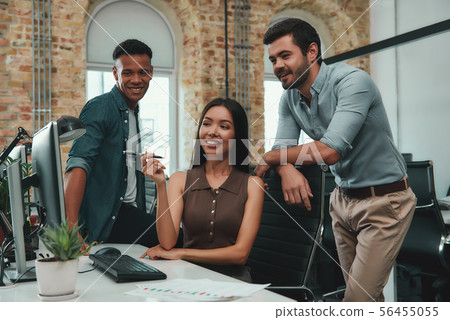 Positive atmosphere. Young beautiful woman pointing at computer monitor and discussing new project 56455055