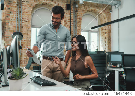 We have great results Young handsome man in casual clothes showing something his digital tablet to 56455448