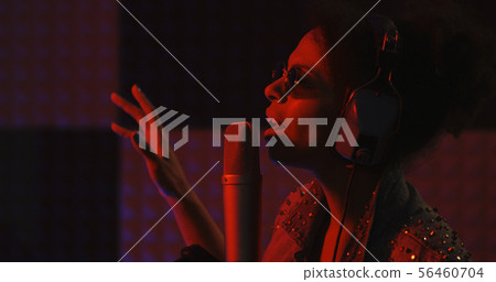 Woman singing in recording booth 56460704
