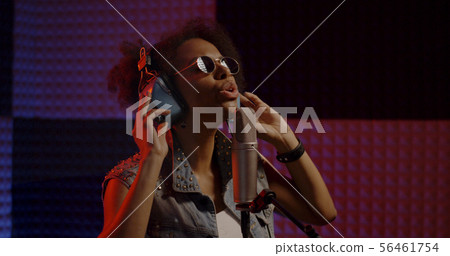Woman singing in recording booth Woman singing in recording booth 56461754