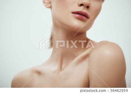 Tenderness and beauty. Cropped photo of attractive young woman with naked shoulder standing against 56462954