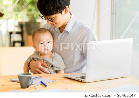 在抱孩子的同時工作的男人 在抱孩子的同時工作的男人 56463147