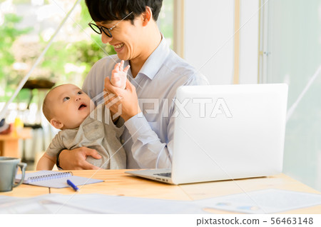 在抱孩子的同時工作的男人 在抱孩子的同時工作的男人 56463148