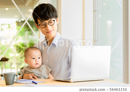 在抱孩子的同時工作的男人 在抱孩子的同時工作的男人 56463150