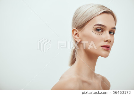 Perfection. Beautiful and young blonde woman with black surgical lines on eyelids and under eyes Perfection. Beautiful and young blonde woman with black surgical lines on eyelids and under eyes 56463173