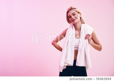Healthy and happy. Positive and cute blonde woman with towel on shoulders looking at camera with Healthy and happy. Positive and cute blonde woman with towel on shoulders looking at camera with 56463694