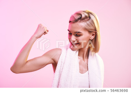 You are stronger than you think Attractive young sporty woman showing her bicep and smiling while You are stronger than you think Attractive young sporty woman showing her bicep and smiling while 56463698