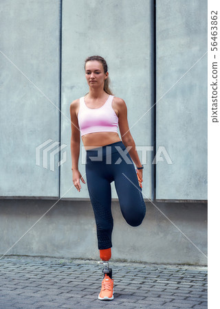 Warming up. Young and beautiful woman with leg prosthesis in sports clothing stretching before Warming up. Young and beautiful woman with leg prosthesis in sports clothing stretching before 56463862