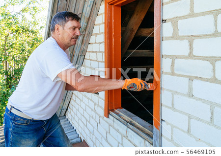 Senior man painting wooden windows using Senior man painting wooden windows using 56469105