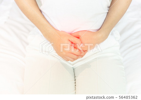 stomachache in young Asian woman sitting on bed stomachache in young Asian woman sitting on bed 56485362