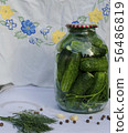 Pickled cucumbers in glass jar.  56486819