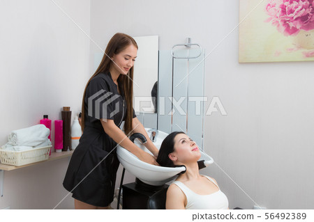 woman wash their hair in a beauty salon woman wash their hair in a beauty salon 56492389