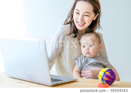 在抱孩子的同時操作電腦的女人 56504583
