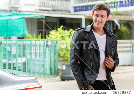Happy young handsome rebellious man thinking outdoors Happy young handsome rebellious man thinking outdoors 56519877
