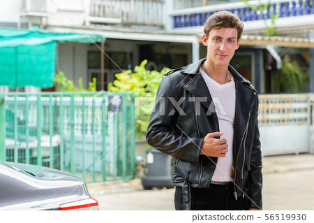 Young handsome rebellious man looking at camera outdoors Young handsome rebellious man looking at camera outdoors 56519930