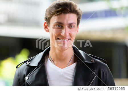 Face of happy young handsome rebellious man thinking outdoors Face of happy young handsome rebellious man thinking outdoors 56519965