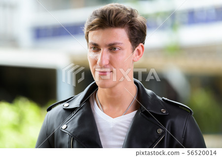 Face of young handsome rebellious man thinking outdoors Face of young handsome rebellious man thinking outdoors 56520014