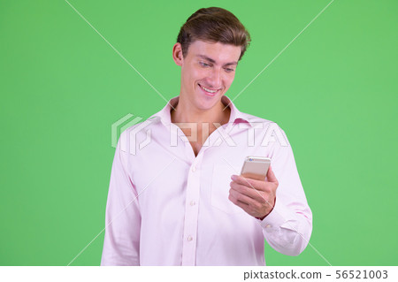 Portrait of young happy businessman using phone 56521003